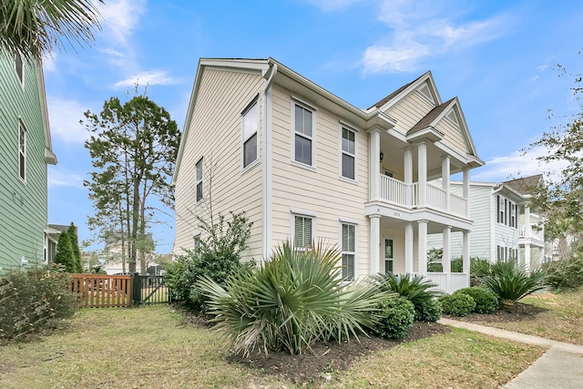 view of front of property with fence and a balcony