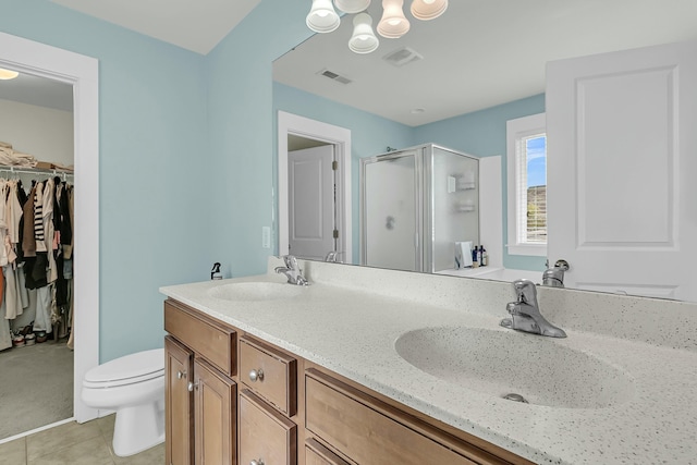 full bath with visible vents, a sink, a shower stall, and double vanity