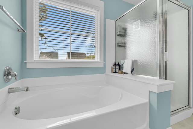 bathroom with a stall shower and a garden tub