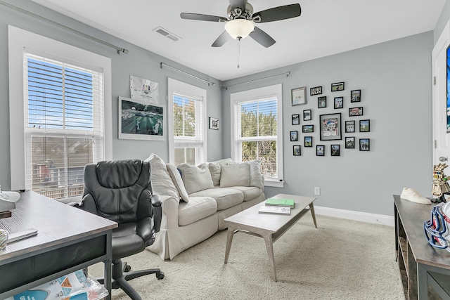 carpeted office with baseboards, visible vents, and ceiling fan