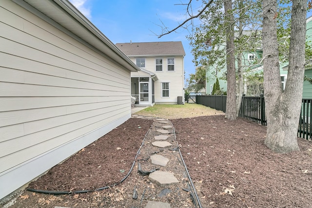 view of yard featuring a sunroom and a fenced backyard