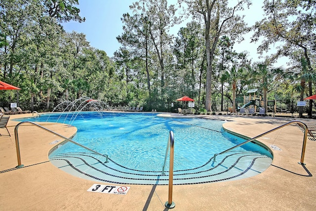 pool featuring fence, playground community, and a patio