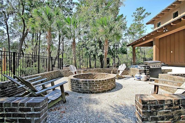 view of patio featuring a fire pit, grilling area, and a fenced backyard