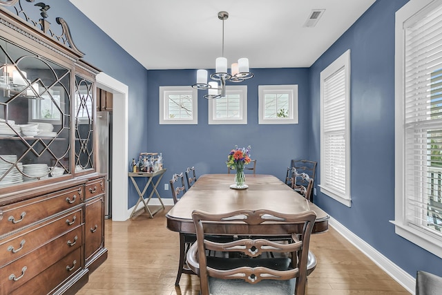 dining area featuring a healthy amount of sunlight, light wood-style flooring, and baseboards