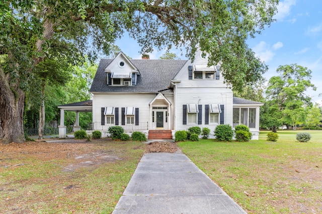 view of front of property with a front lawn, a chimney, and a shingled roof