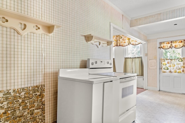 laundry area with washer / clothes dryer and wallpapered walls