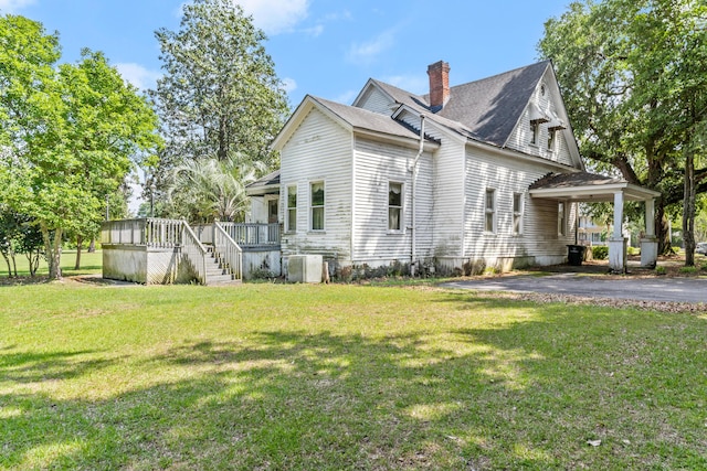 view of home's exterior featuring a chimney, a yard, central air condition unit, a deck, and stairs