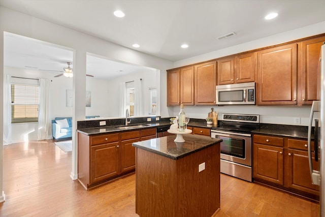 9747 Seed St, Ladson, SC 29456 - kitchen with appliances with stainless steel finishes, a sink, a kitchen island, brown cabinetry, and recessed lighting
