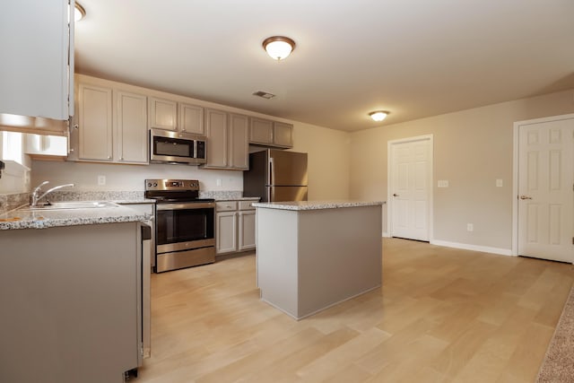 8285 Little Sydneys Way N, Charleston, SC 29406 - kitchen with stainless steel appliances, light wood finished floors, a center island, light stone countertops, and gray cabinetry