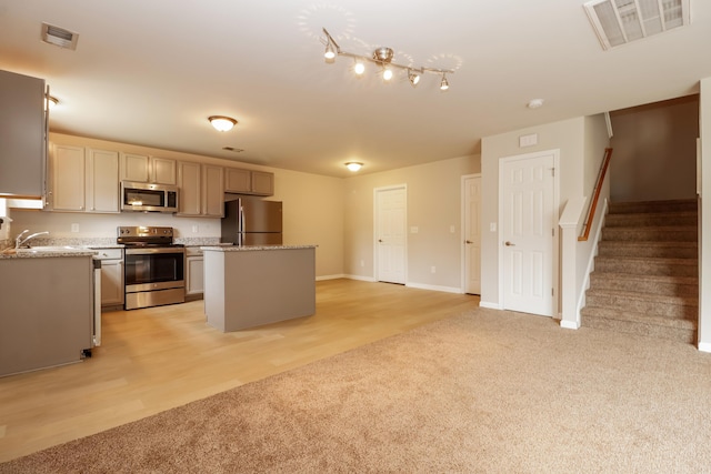 8285 Little Sydneys Way N, Charleston, SC 29406 - kitchen featuring appliances with stainless steel finishes, light carpet, a kitchen island, light stone counters, and light wood-type flooring