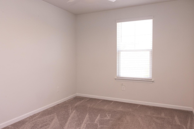 unfurnished room featuring carpet, plenty of natural light, baseboards, and a ceiling fan