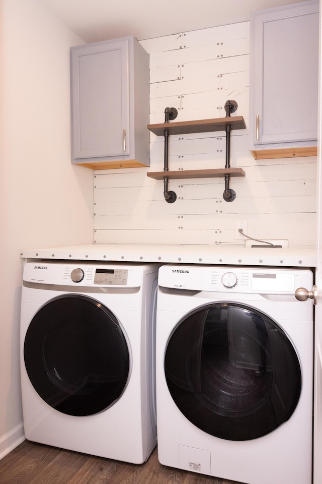 laundry area with cabinet space, independent washer and dryer, and wood finished floors