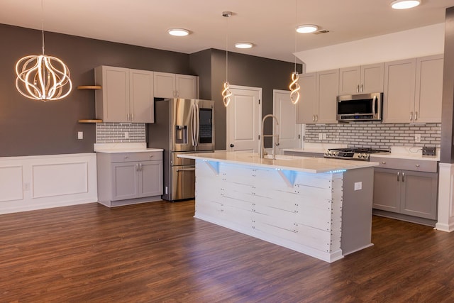 kitchen featuring stainless steel appliances, a sink, light countertops, and tasteful backsplash