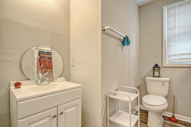 bathroom with hardwood / wood-style flooring, vanity, and toilet