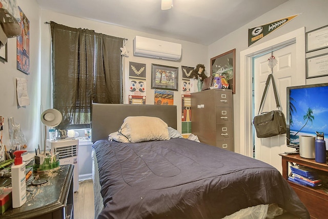 bedroom featuring an AC wall unit, ceiling fan, and hardwood / wood-style flooring