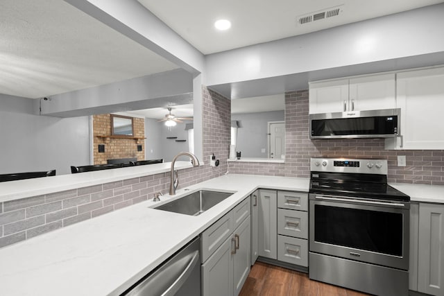 kitchen with a sink, backsplash, visible vents, and stainless steel appliances