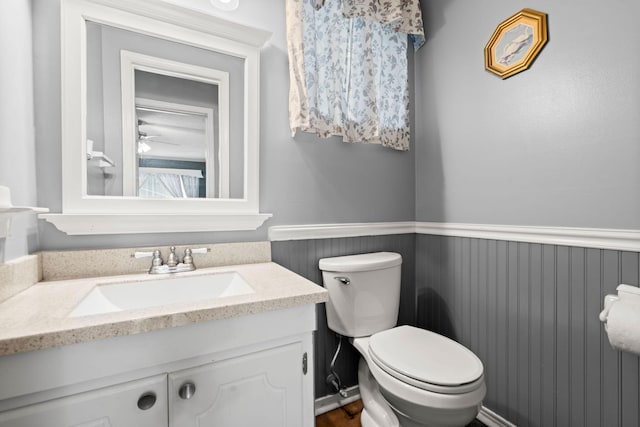 bathroom with vanity, wainscoting, and toilet