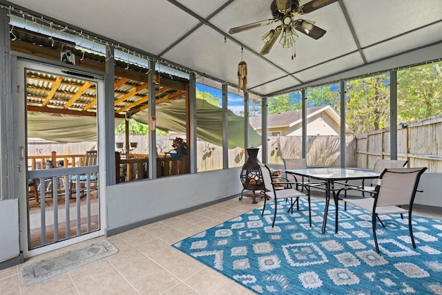 sunroom / solarium featuring a ceiling fan and outdoor dining area