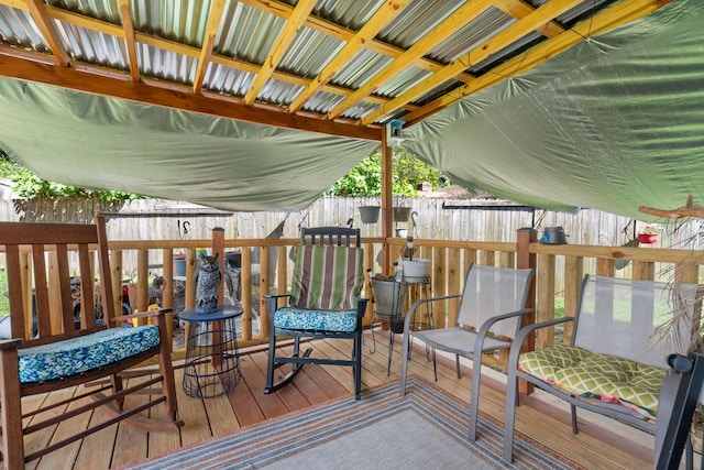 wooden terrace featuring a storage shed, an outbuilding, and a fenced backyard