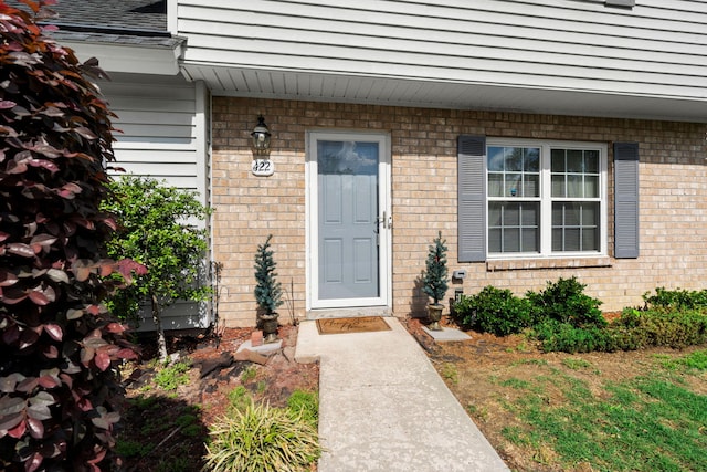 entrance to property featuring brick siding
