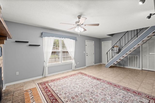 foyer with visible vents, a ceiling fan, tile patterned flooring, and stairs
