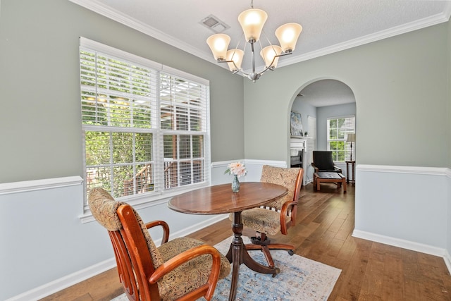 340 Stefan Dr, Charleston, SC 29412 - dining area with arched walkways, a fireplace, a chandelier, hardwood / wood-style floors, and ornamental molding