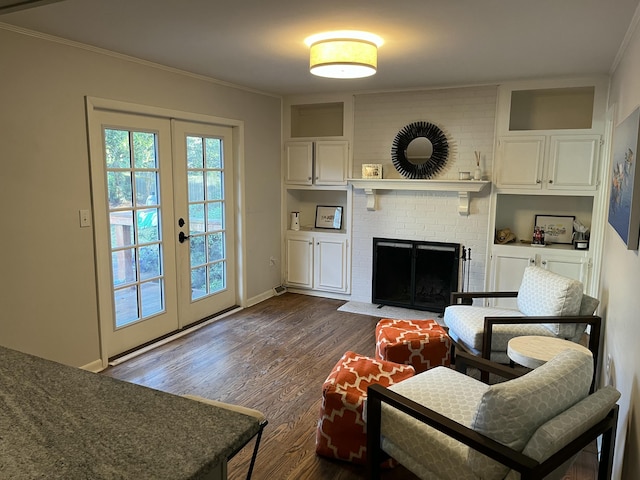 living room with a fireplace, crown molding, dark wood-type flooring, and french doors