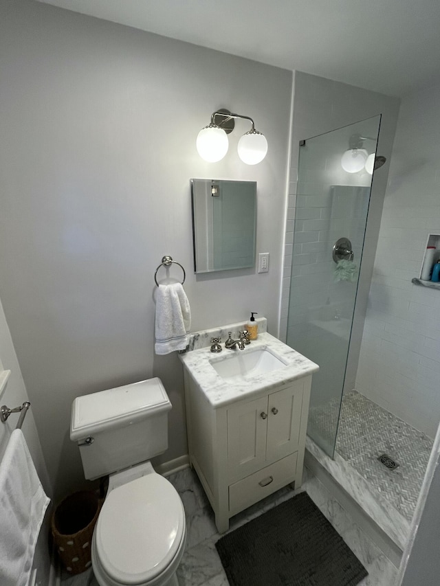 bathroom featuring a tile shower, vanity, and toilet