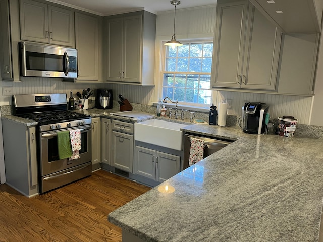 kitchen with light stone countertops, dark hardwood / wood-style flooring, stainless steel appliances, and sink