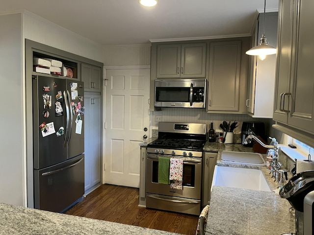 kitchen with gray cabinets, light stone counters, hanging light fixtures, and appliances with stainless steel finishes