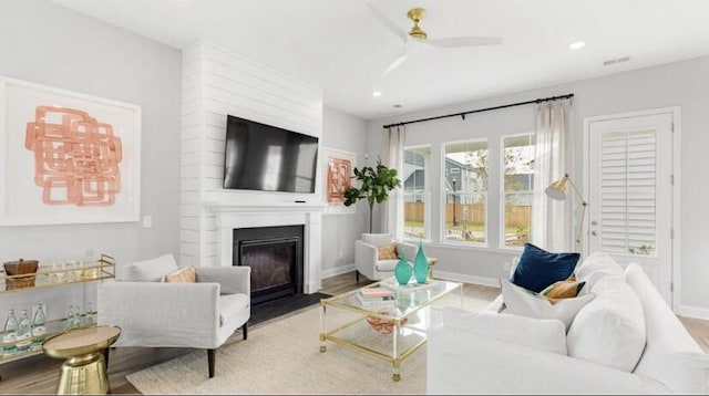 living area featuring recessed lighting, ceiling fan, wood finished floors, and a fireplace