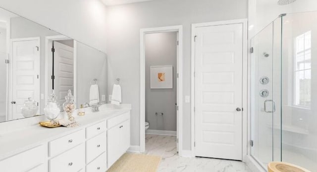 bathroom featuring vanity, marble finish floor, toilet, baseboards, and a shower stall