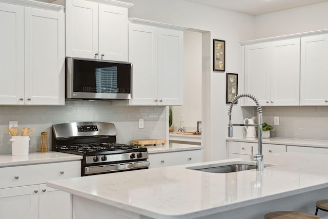 kitchen with sink, white cabinets, and appliances with stainless steel finishes