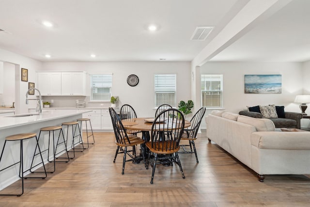 dining space with sink and light hardwood / wood-style flooring