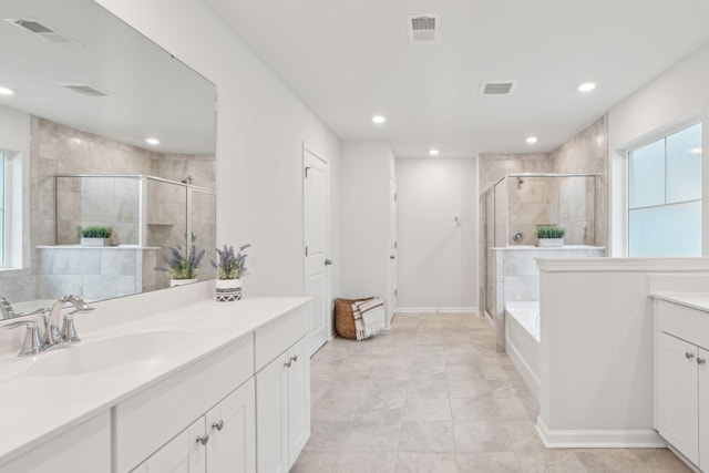 bathroom with tile patterned floors, vanity, plus walk in shower, and a wealth of natural light