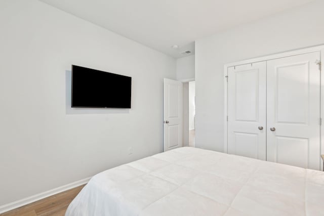 bedroom with hardwood / wood-style floors and a closet