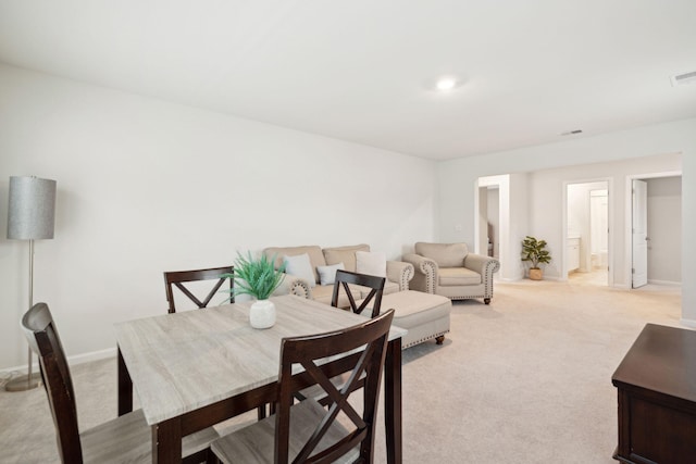 dining space featuring light carpet