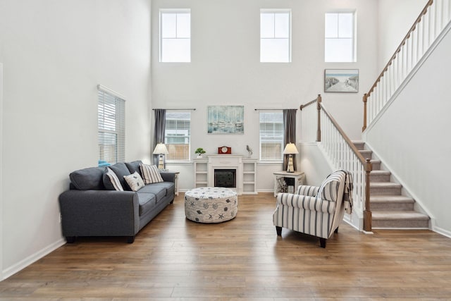 living room featuring hardwood / wood-style flooring and a towering ceiling