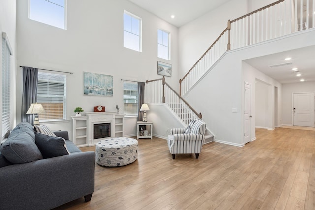 living room featuring light hardwood / wood-style floors and a high ceiling