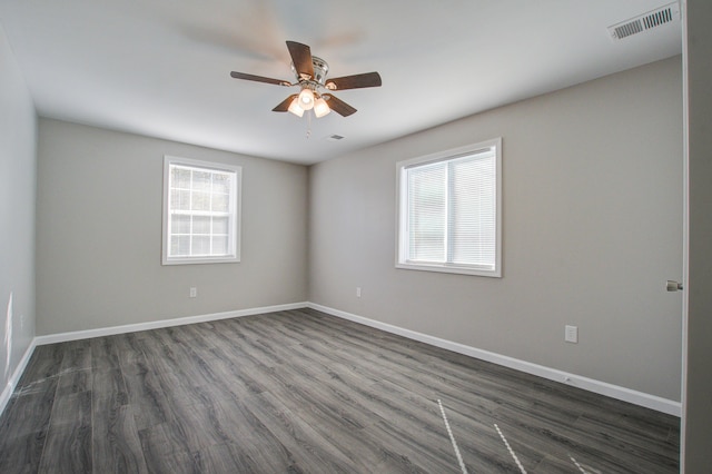 spare room with dark wood-type flooring and ceiling fan