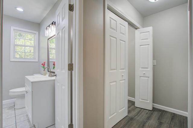 bathroom with hardwood / wood-style floors, vanity, and toilet