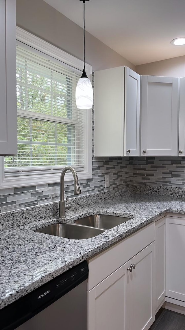 kitchen with stainless steel dishwasher, white cabinetry, and sink