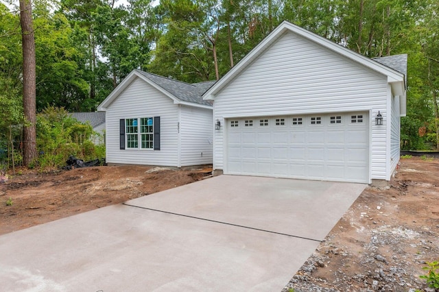 view of front facade with a garage and a shingled roof