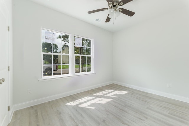 empty room with visible vents, ceiling fan, baseboards, and wood finished floors