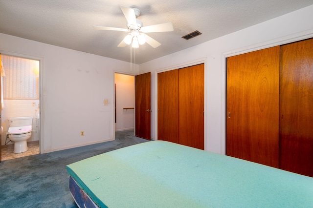 carpeted bedroom with multiple closets, ceiling fan, ensuite bathroom, and a textured ceiling