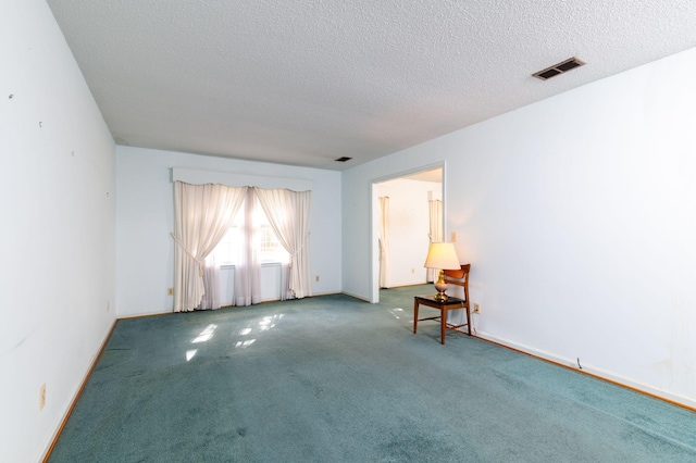 carpeted spare room featuring a textured ceiling