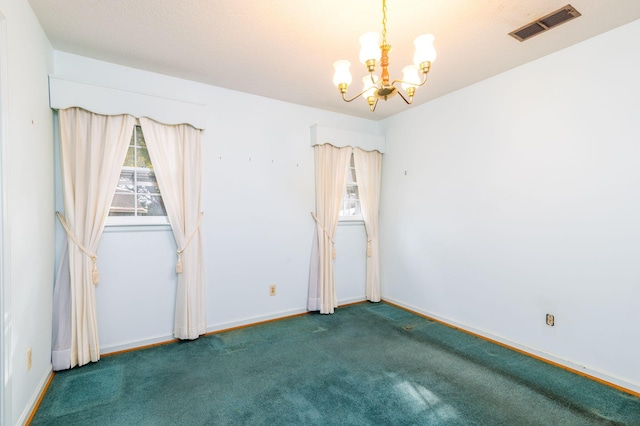 carpeted empty room with an inviting chandelier