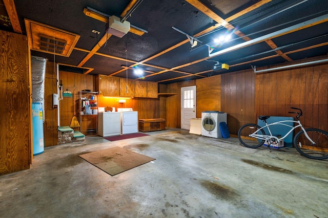 garage featuring washer and clothes dryer, wood walls, and a garage door opener