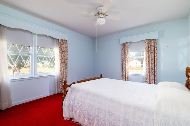 carpeted bedroom featuring ceiling fan and multiple windows