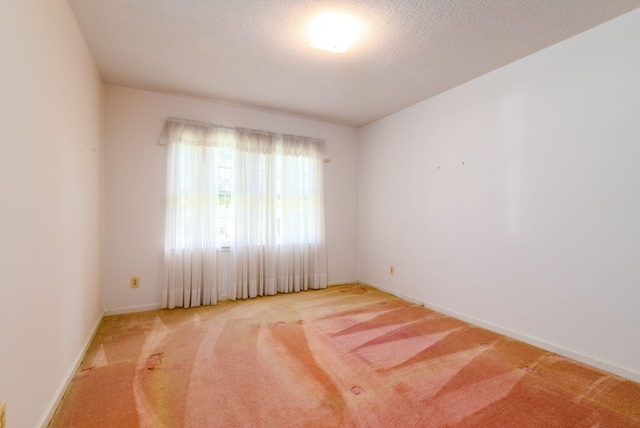 empty room featuring a textured ceiling and light carpet